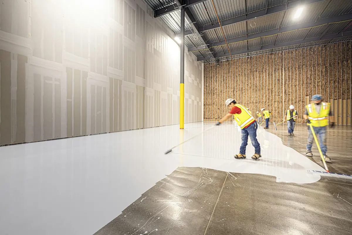 Crew applying epoxy to a warehouse floor
